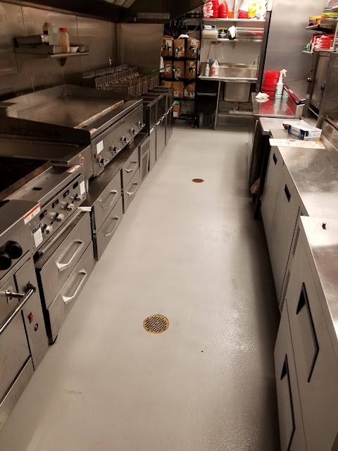 Professionally cleaned commercial kitchen floor and equipment